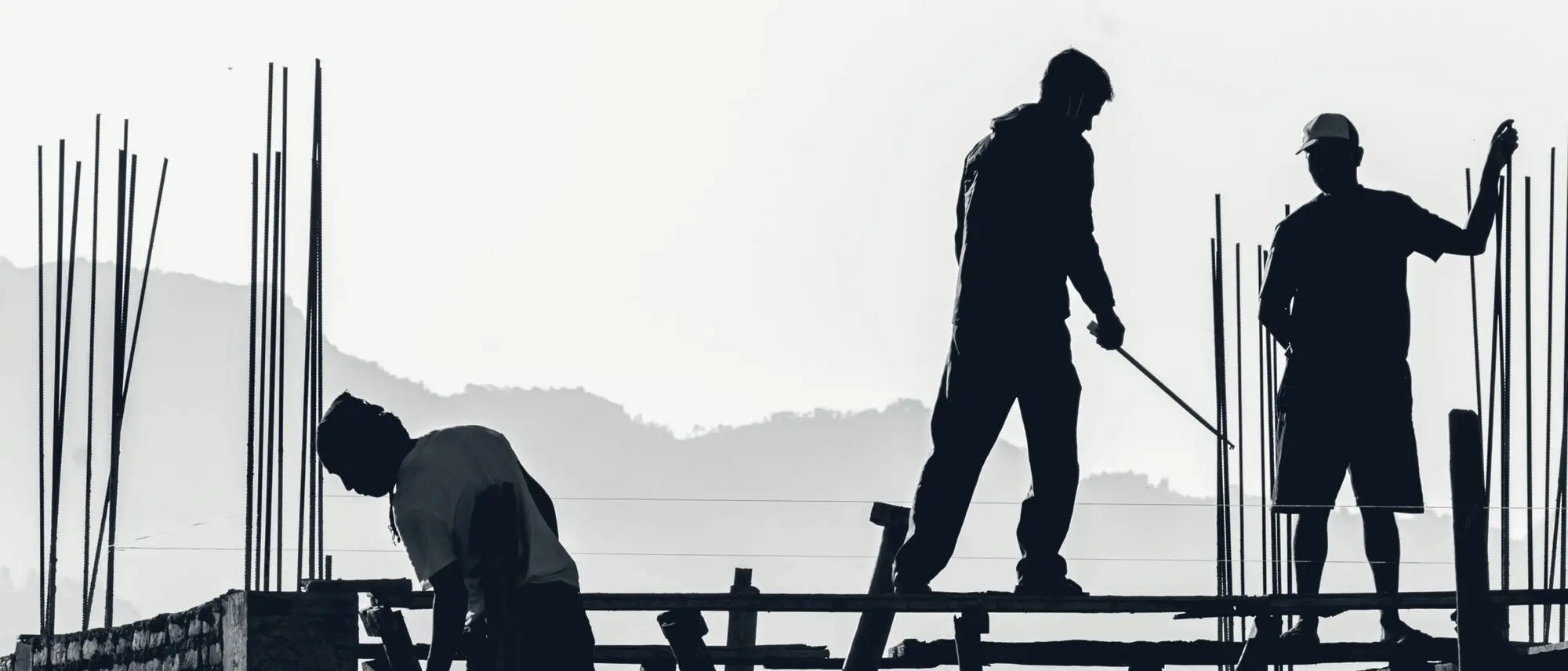 Tradespeople silhouetted against the evening sky on a job site
