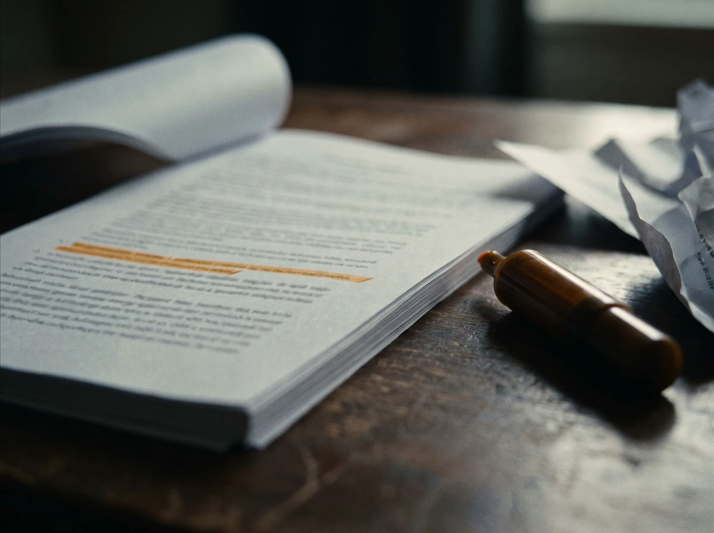 A printed report on a dark desk with one line highlighted in amber