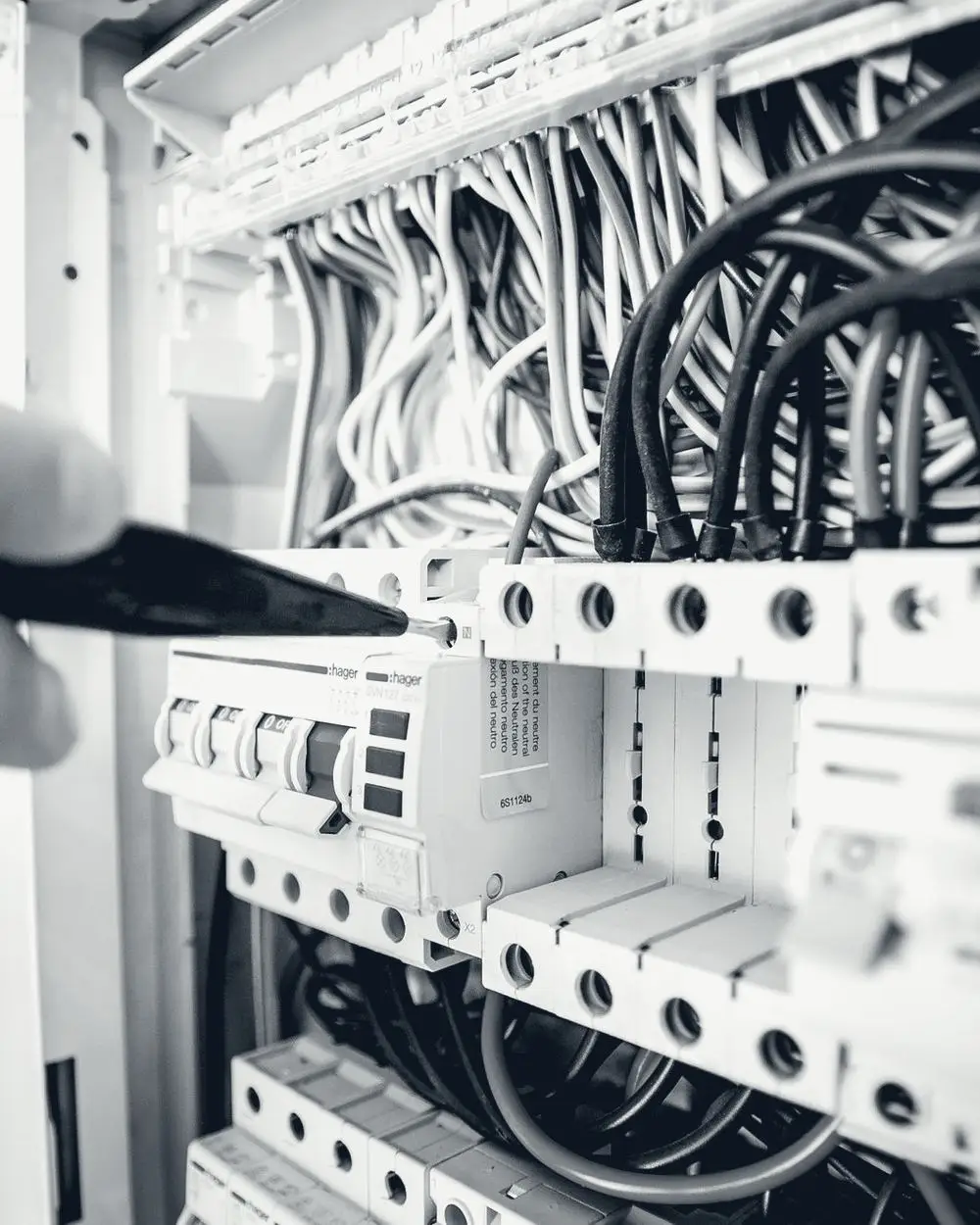 Electrician’s hands working inside a residential switchboard