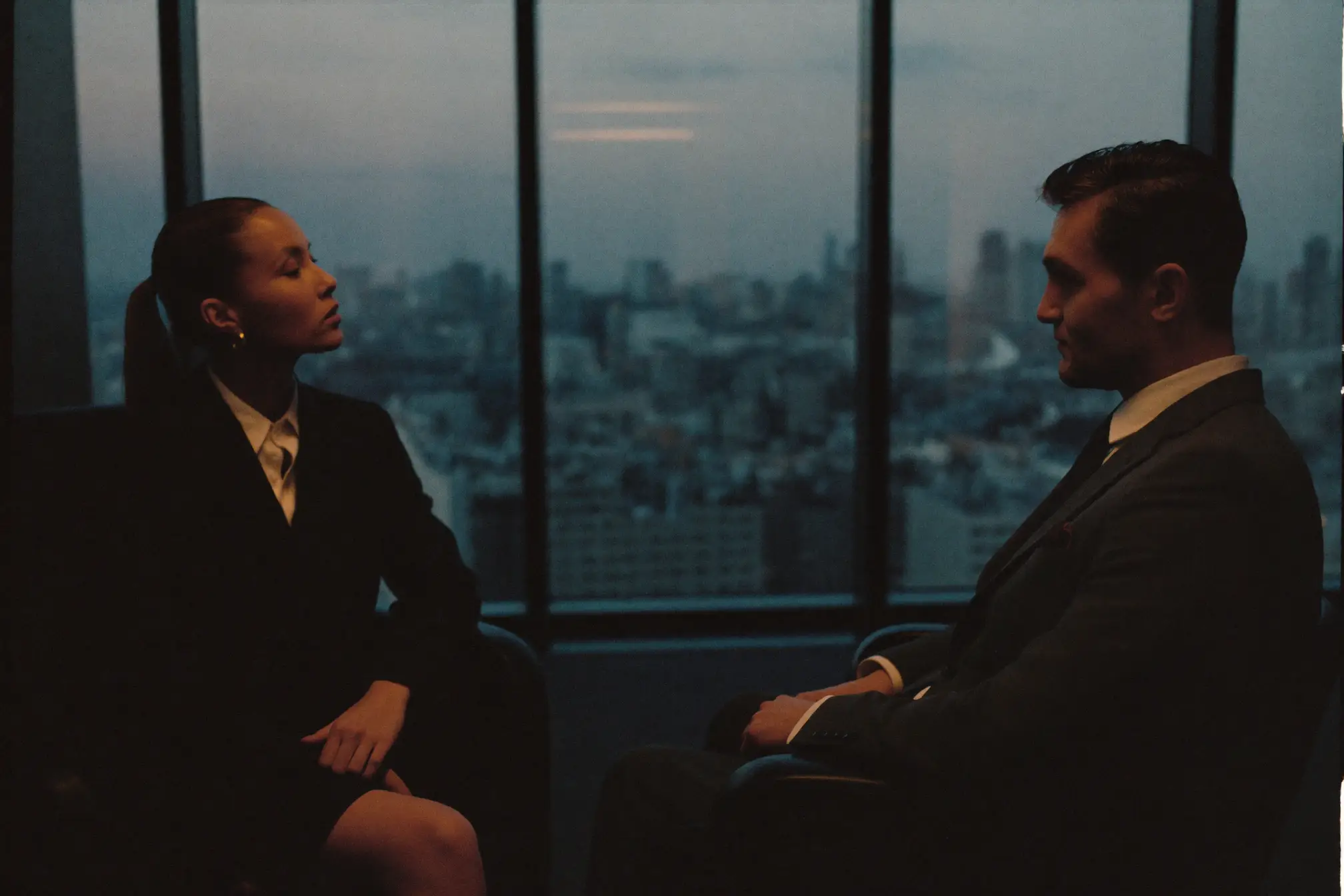 Two lawyers in conversation in a boardroom at dusk